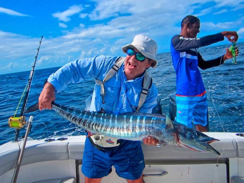 An angler with a freshly caught wahoo